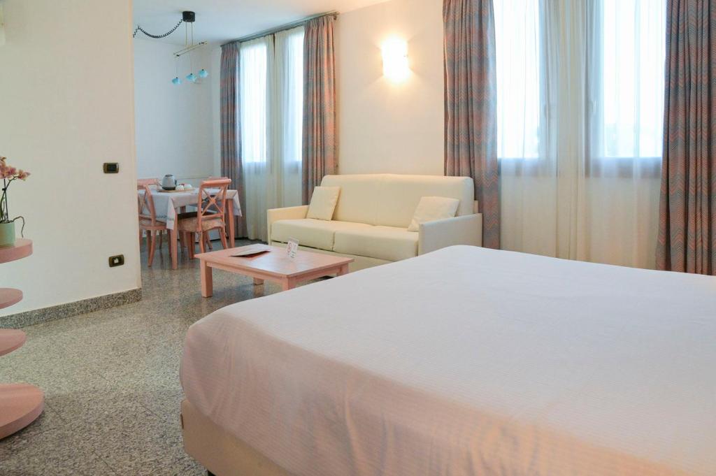 une chambre d'hôtel avec un lit, un canapé et une table dans l'établissement Residence Hotel L'incanto Di Boccadarno, à Marina di Pisa
