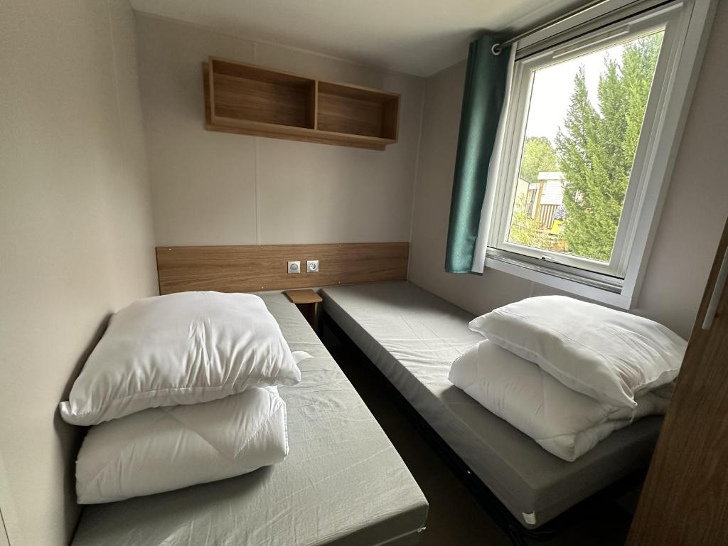 une chambre avec deux lits et une fenêtre dans l'établissement Natuara - L'écrin du Ferret, à Lège-Cap-Ferret 23 autres photos