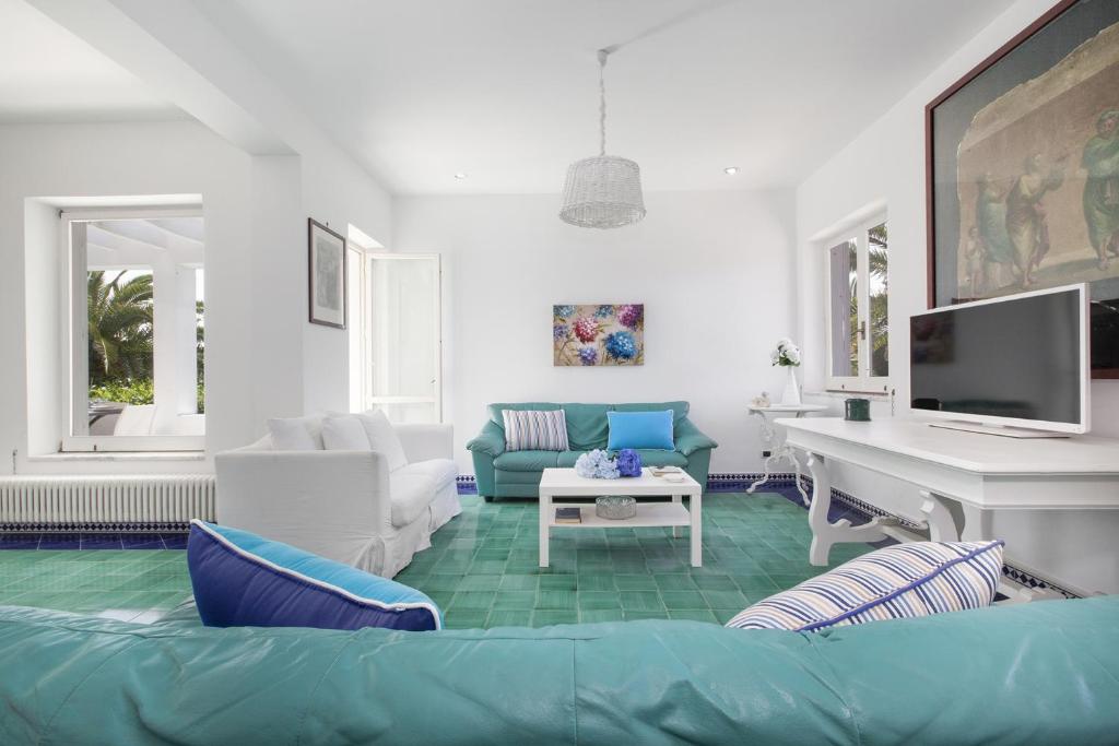 - un salon avec un canapé bleu et un bureau dans l'établissement YourHome - Villa Claudette private pool sea view, à Massa Lubrense