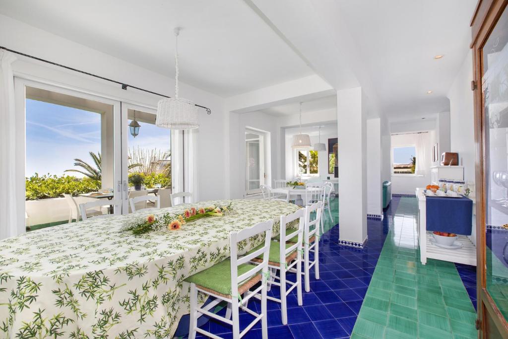 une salle à manger blanche avec une grande table et des chaises dans l'établissement YourHome - Villa Claudette private pool sea view, à Massa Lubrense