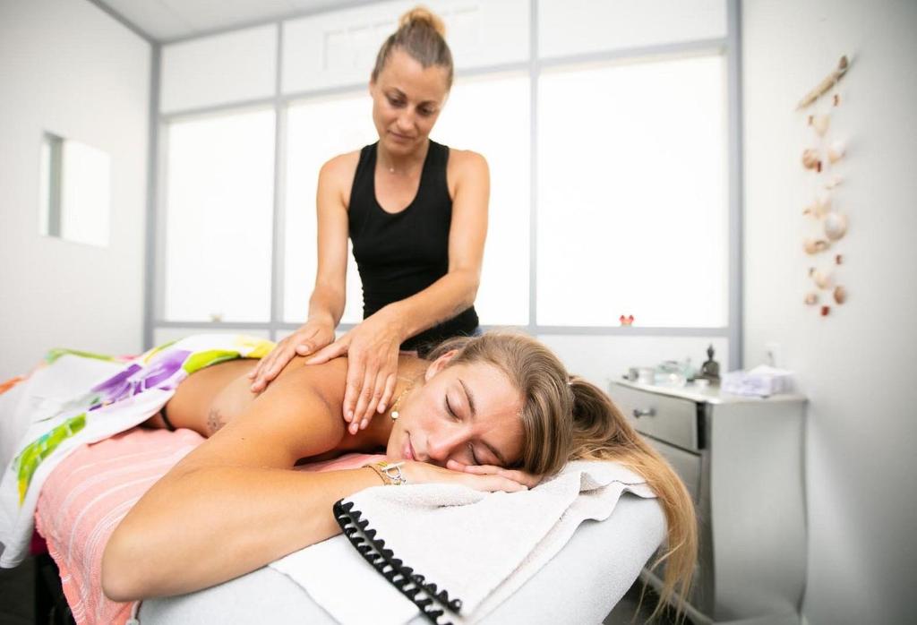 une femme dormant sur un lit avec un thérapeute dans l'établissement Natuara - L'écrin du Ferret, à Lège-Cap-Ferret