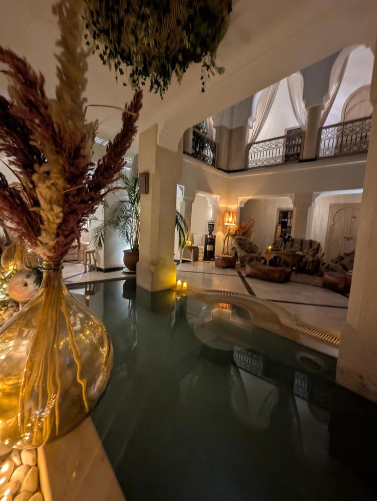 - un hall avec un vase et un palmier dans l'établissement Riad Bamboo Suites & Spa, à Marrakech