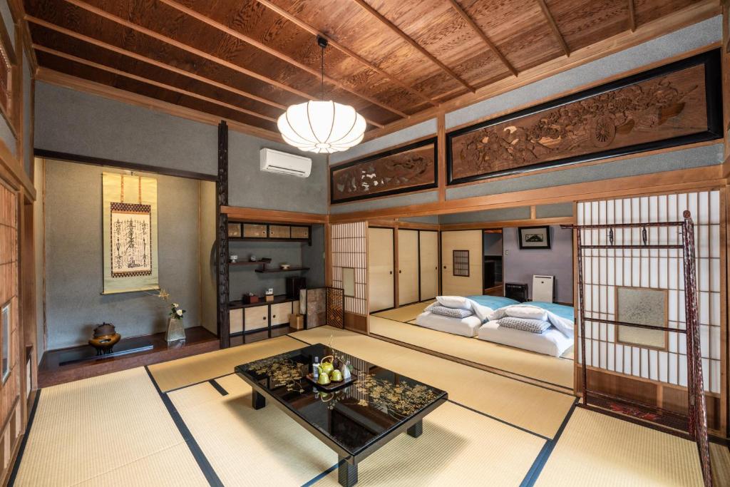 Cette grande chambre comprend un lit et une table. dans l'établissement Temple Lodging Shukubo Kakurinbo, à Minobu