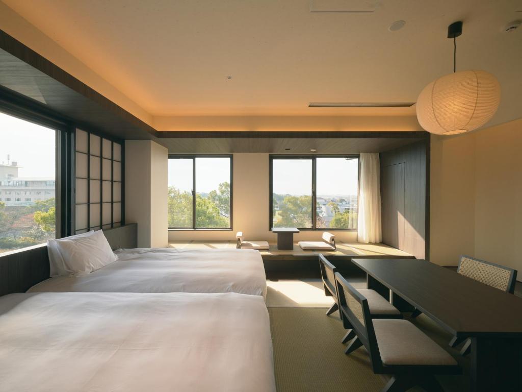 - une chambre avec 2 lits, un bureau et des fenêtres dans l'établissement Ohana, à Yanagawa 37 autres photos
