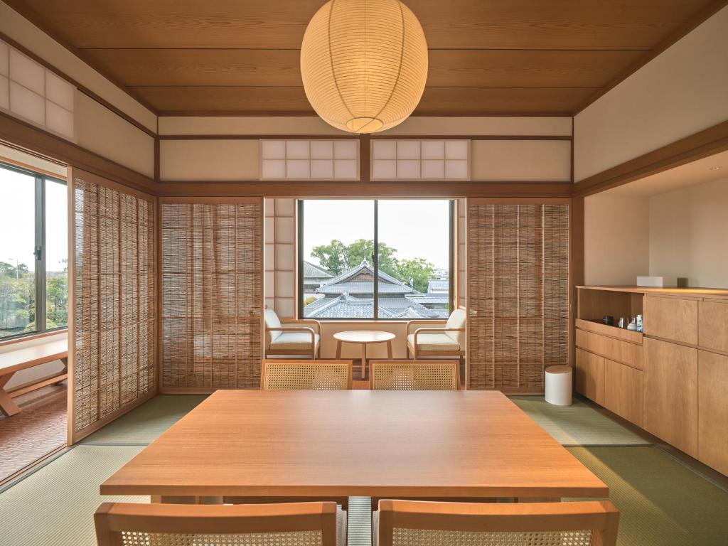 une salle à manger avec une table et des chaises et une grande fenêtre dans l'établissement Ohana, à Yanagawa