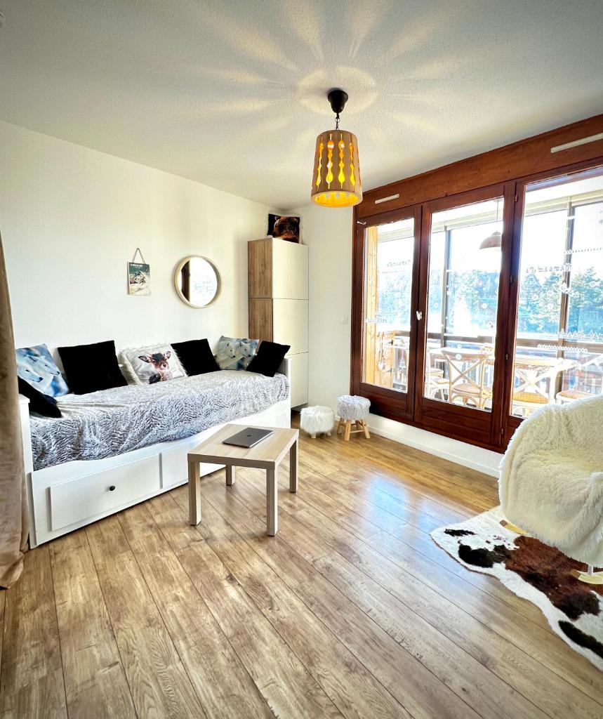un salon avec un lit et une table dans l'établissement La joue du loup, aux pieds des pistes et vue sur montagnes, à La Joue du Loup