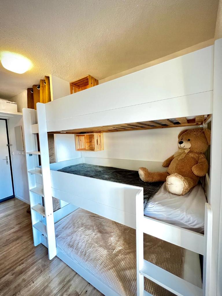 un ours en peluche assis sur la couchette inférieure d'un lit superposé dans l'établissement La joue du loup, aux pieds des pistes et vue sur montagnes, à La Joue du Loup 25 autres photos