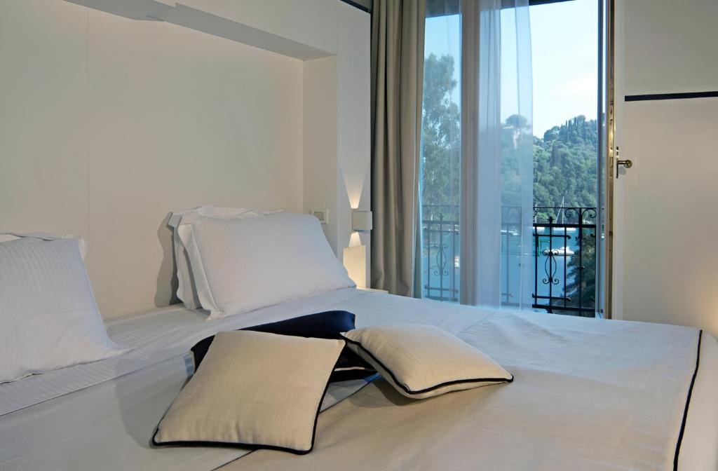 une chambre avec un lit avec deux oreillers dessus dans l'établissement Portofino Deluxe Family Suite - balcony, sea view, private hotel beach, à Portofino