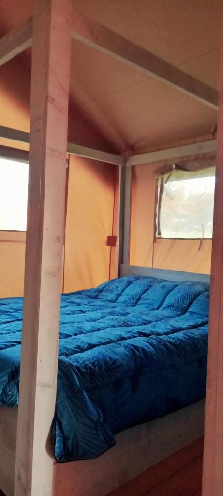 un lit au milieu d'une pièce dans l'établissement SAFARI LODGE MONPAZIER en pleine nature, à Saint-Cassien