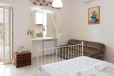 - une chambre blanche avec un lit et un canapé dans l'établissement Pugliaholidayplus - VILLA CASSANO, à Polignano a Mare