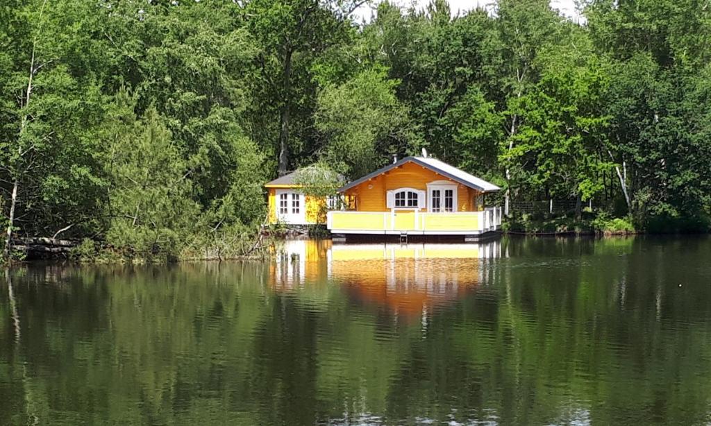 une maison sur un bateau au milieu d'un lac dans l'établissement Chalet flottant sur lac et spa, à Mios