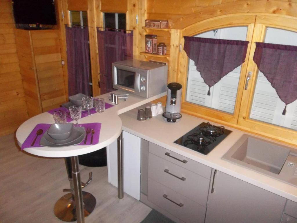 - une cuisine avec un comptoir blanc et un four micro-ondes dans l'établissement Chalet flottant sur lac et spa, à Mios