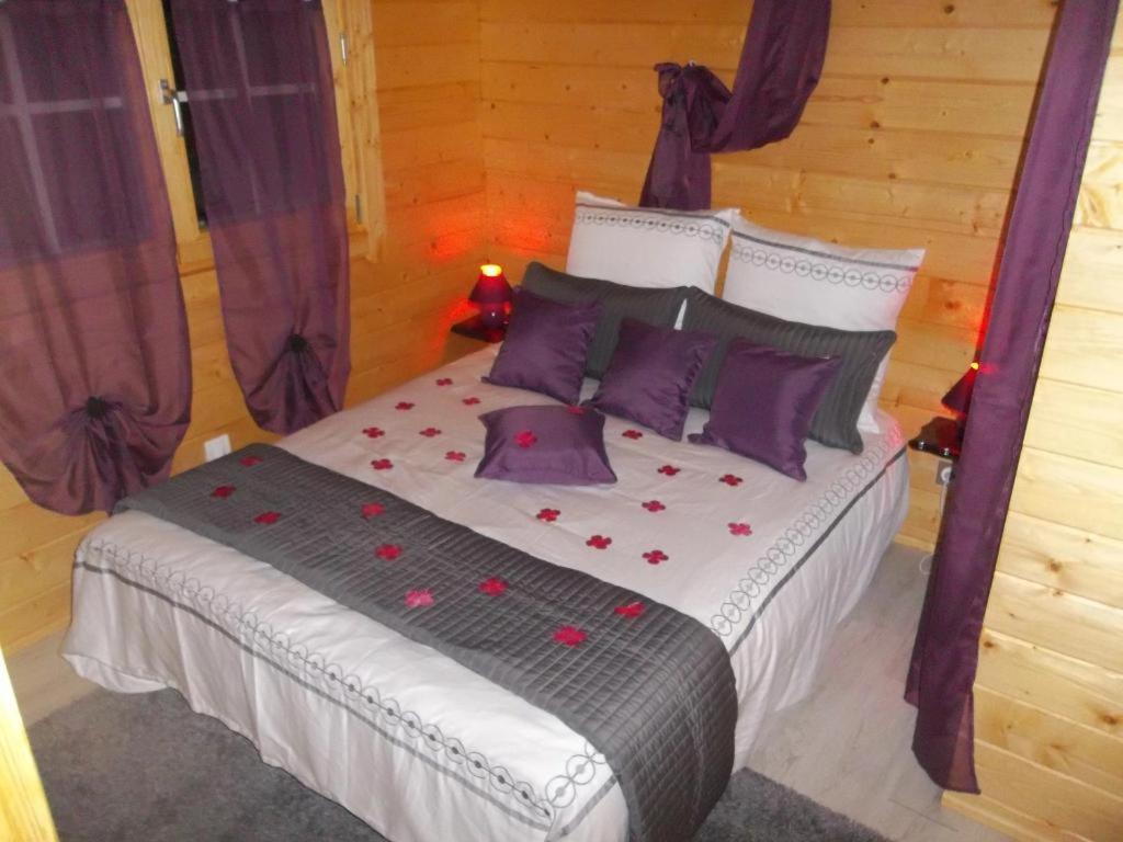 une chambre avec un lit avec des fleurs rouges dessus dans l'établissement Chalet flottant sur lac et spa, à Mios