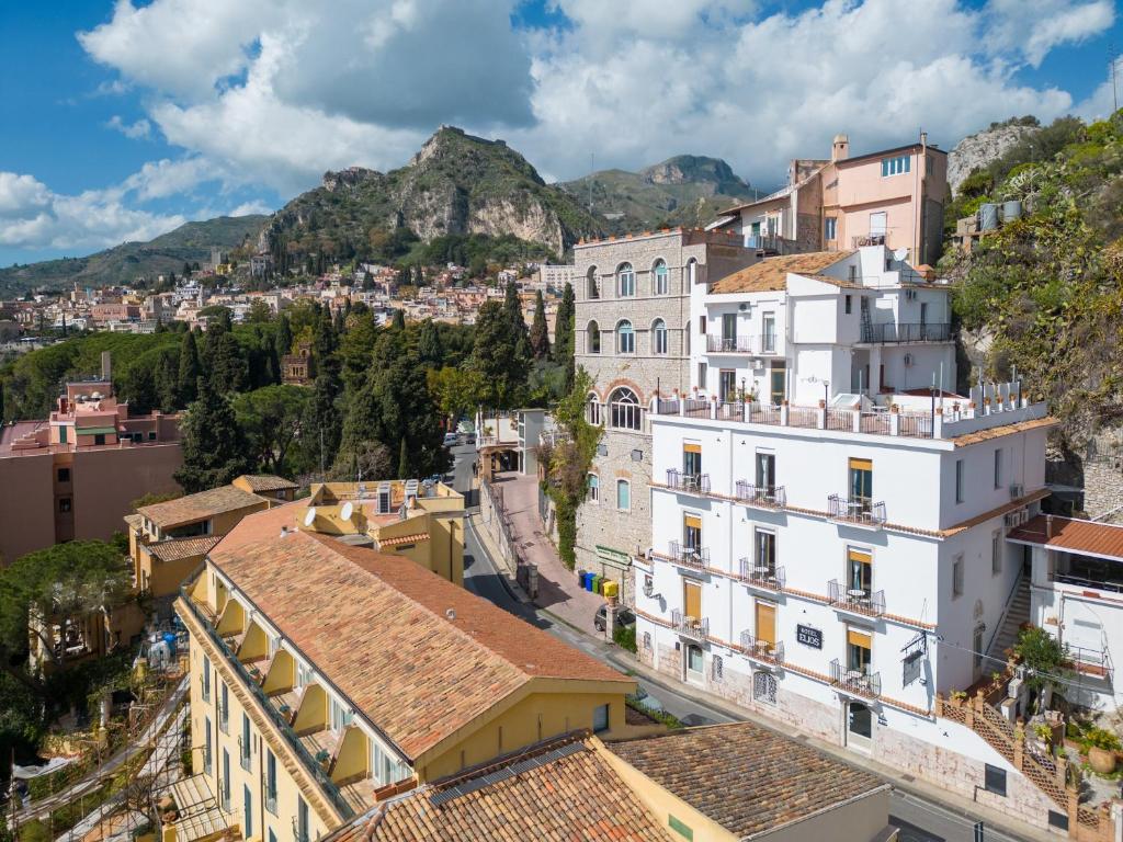 une vue d'une ville avec des montagnes en arrière-plan dans l'établissement Hotel Elios Tao, à Taormine