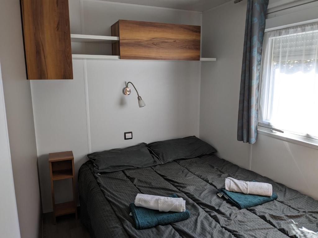 une chambre avec un lit avec deux oreillers dessus dans l'établissement Joli Mobil-Home 3 chambres 34 Siblu La Réserve, à Gastes 27 autres photos