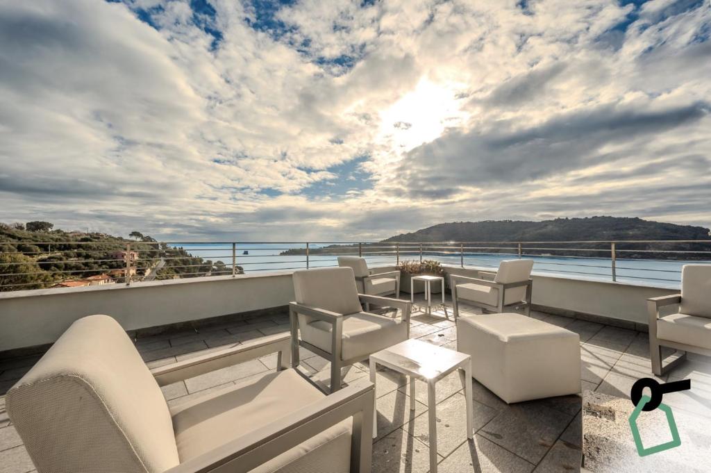 un balcon avec des chaises blanches et une vue sur l'océan dans l'établissement HOTIDAY Room Collection - Porto Venere, à Portovenere