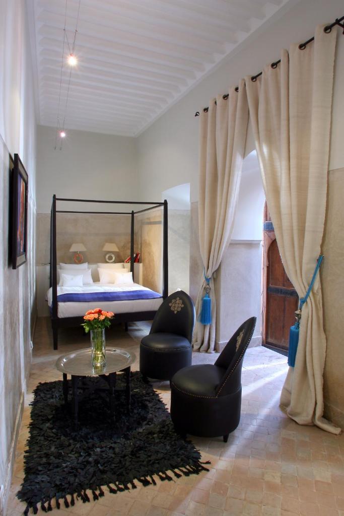 une chambre avec un lit, deux chaises et une table dans l'établissement Riad Dar Asam, à Marrakech