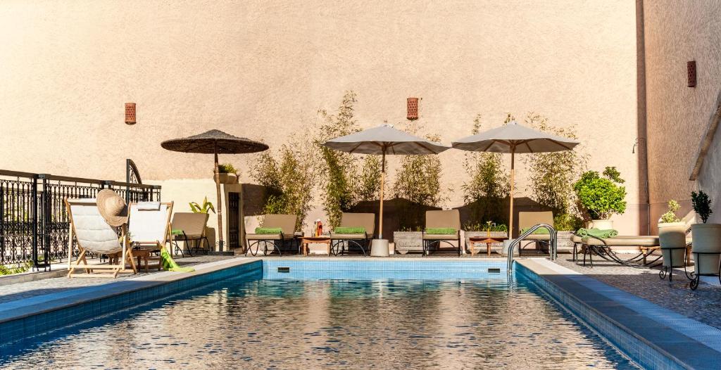 - une piscine avec des parasols, des tables et des chaises dans l'établissement Riad Sougtani, à Marrakech 37 autres photos