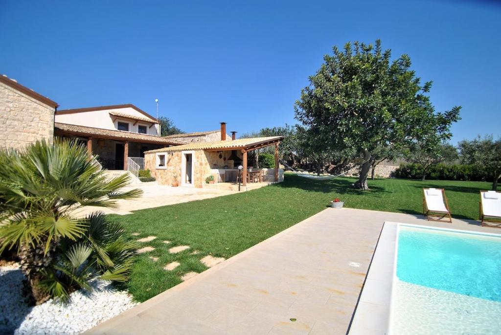 une cour avec une maison et une piscine dans l'établissement Casa Natia - IsulaTravel, à Modica