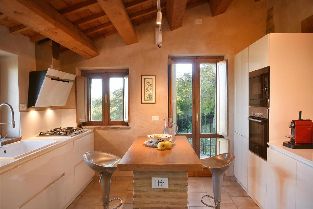 une cuisine avec une table, des chaises et un évier dans l'établissement Refugium VERITAS - entire Villa with Pool, à Cupramontana