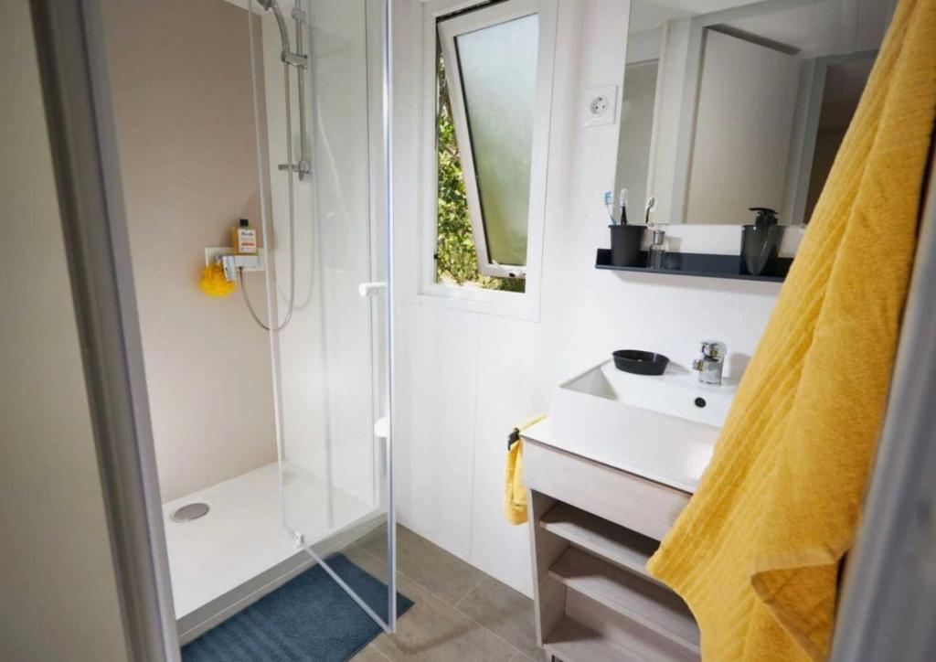 une salle de bain avec douche et lavabo dans l'établissement Camping - Parc aquatique - ccaghdi, à Saint-Jean-de-Monts