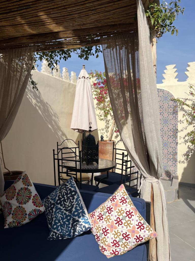 - une terrasse couverte avec des oreillers sur un canapé et une table dans l'établissement RIAD JULILU PRIVATISE, à Marrakech