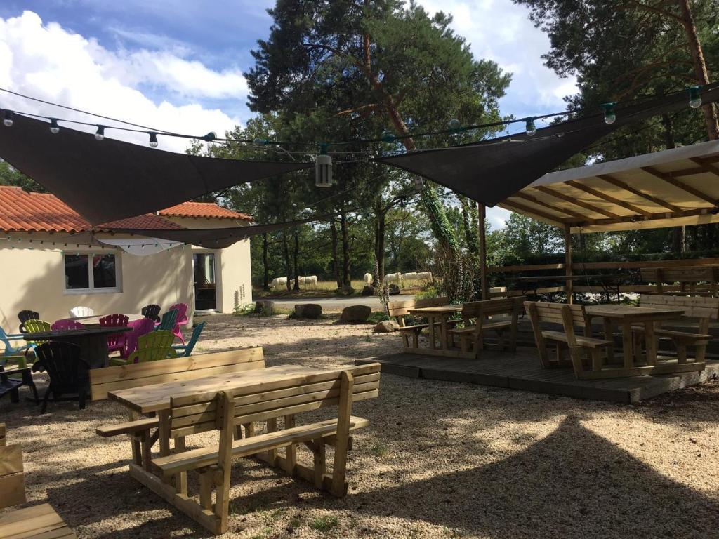 un groupe de tables de pique-nique et de parasols dans un parc dans l'établissement Mobilhome cosy Aulywan, à La Boissière-de-Montaigu