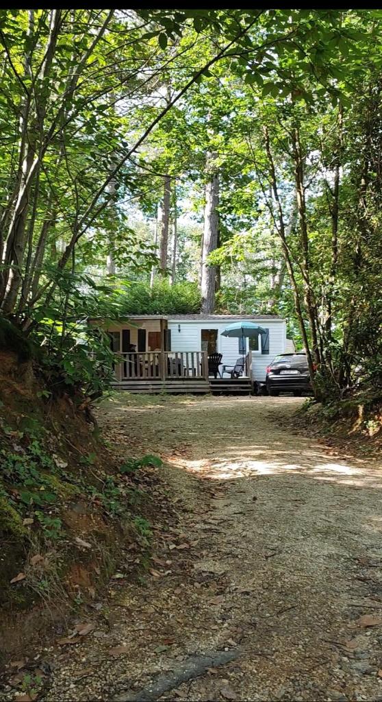 un wagon garé dans les bois avec une voiture garée dans l'établissement Tiny Sweet Home, à Saint-Chéron