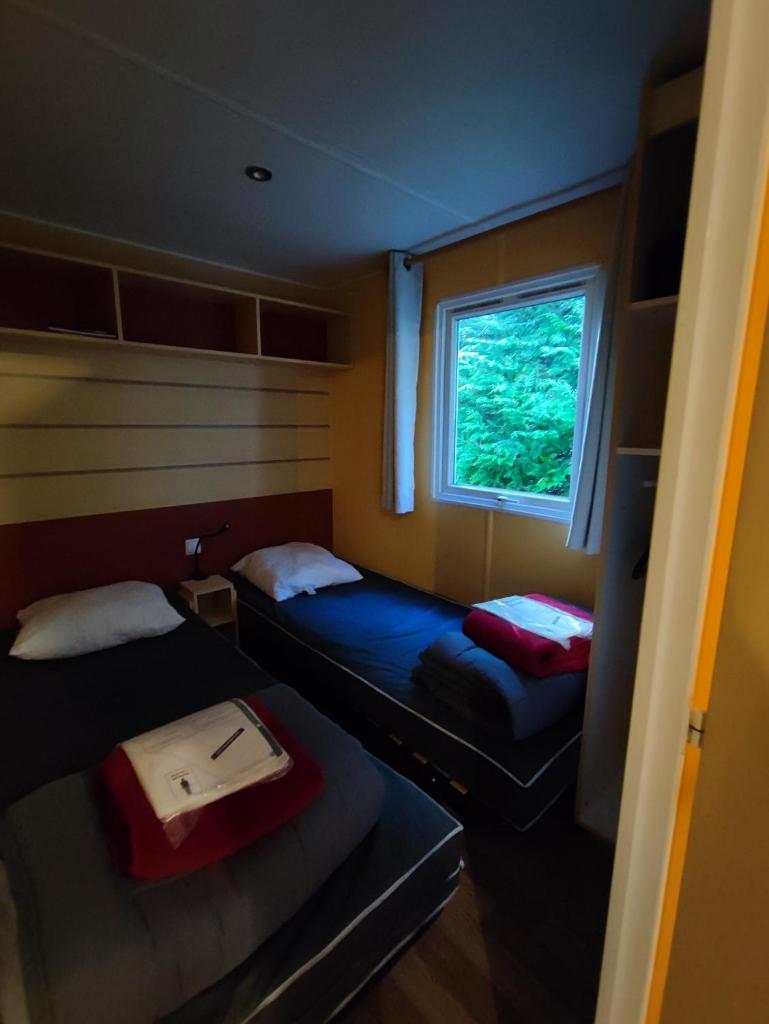 une petite chambre avec deux lits et une fenêtre dans l'établissement Tiny Sweet Home, à Saint-Chéron 19 autres photos
