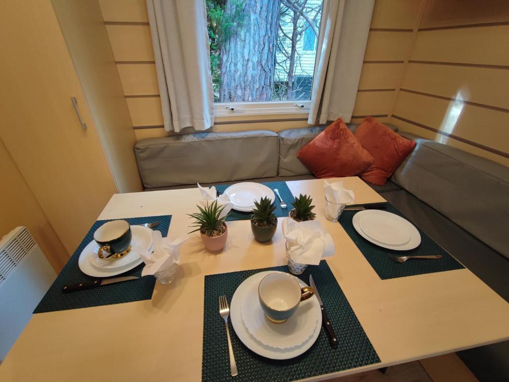 une table avec des assiettes et des ustensiles dessus dans l'établissement Tiny Sweet Home, à Saint-Chéron