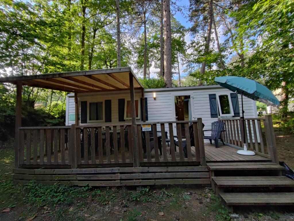 une petite maison avec une terrasse et un parasol dans l'établissement Tiny Sweet Home, à Saint-Chéron