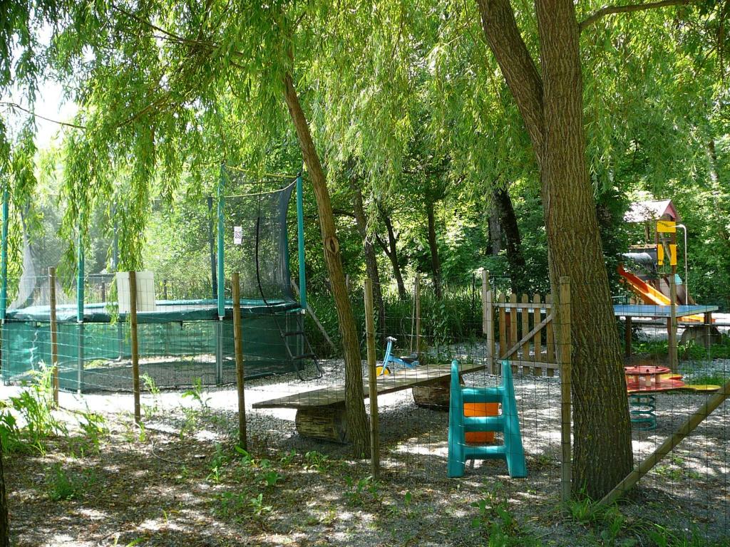 un parc avec une aire de jeux avec un arbre et un banc dans l'établissement La Valière, à Chorges 8 autres photos