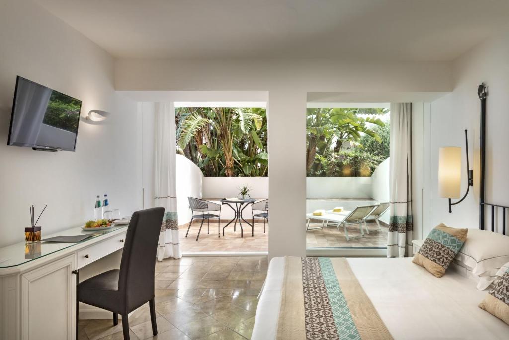 - un salon avec un bureau dans l'établissement El Faro Hotel & Spa, à Porto Conte