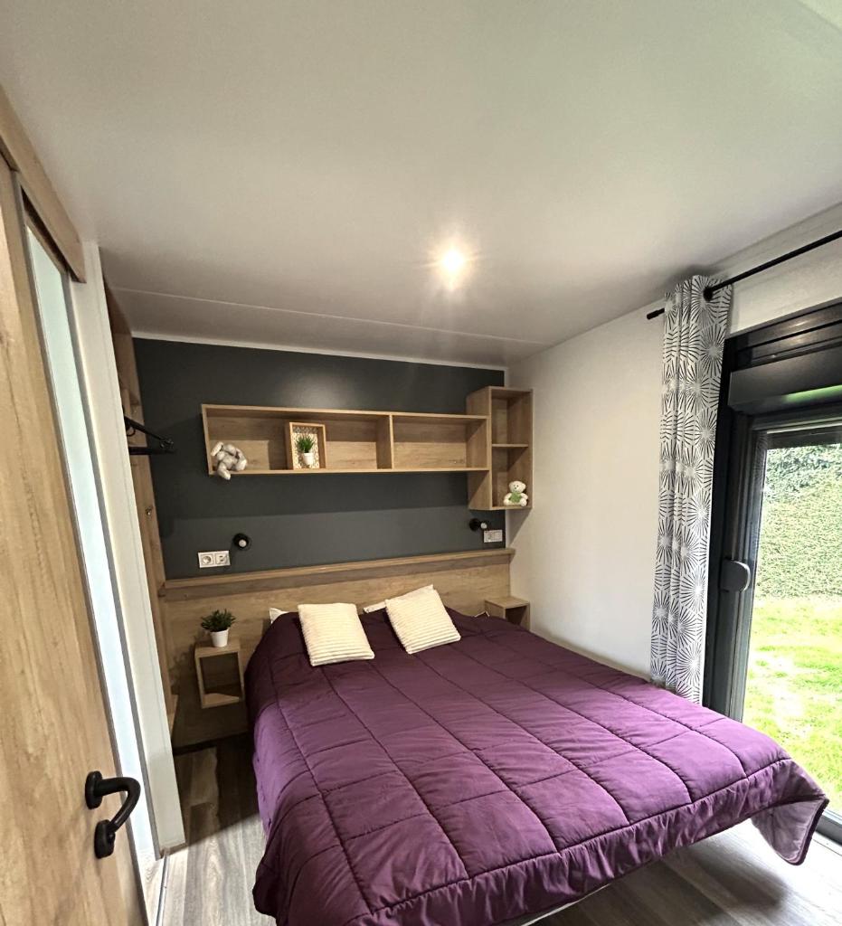 une chambre avec un lit violet et une fenêtre dans l'établissement Camping de Keranterec, à La Forêt-Fouesnant