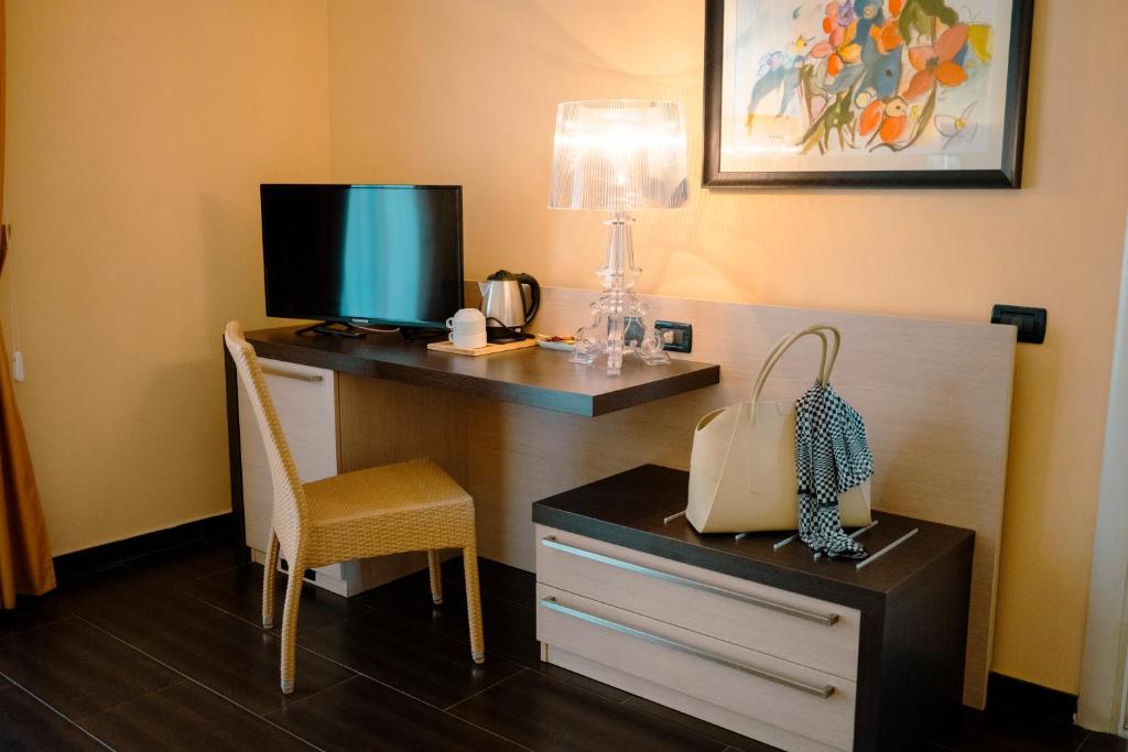 une pièce avec un bureau, une télévision et une chaise dans l'établissement UNICO Cannamele Escape Tropea by Life Resorts, à Parghelia