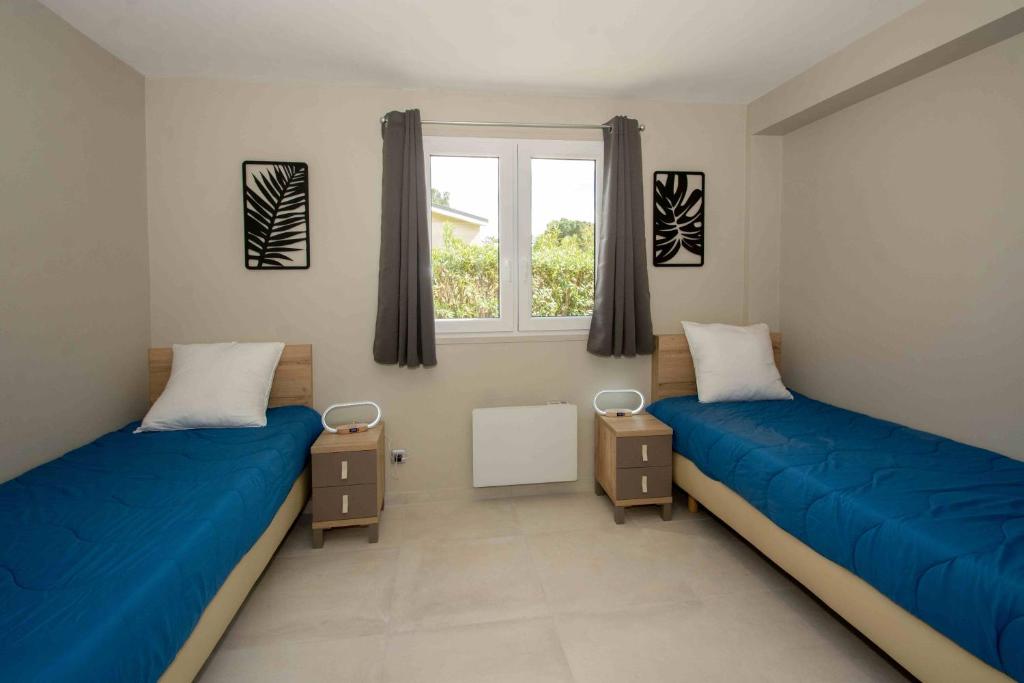 deux lits dans une chambre avec une fenêtre dans l'établissement Camping Montana Parc - Coeur de l'Estérel - Maeva, à Puget-sur Argens