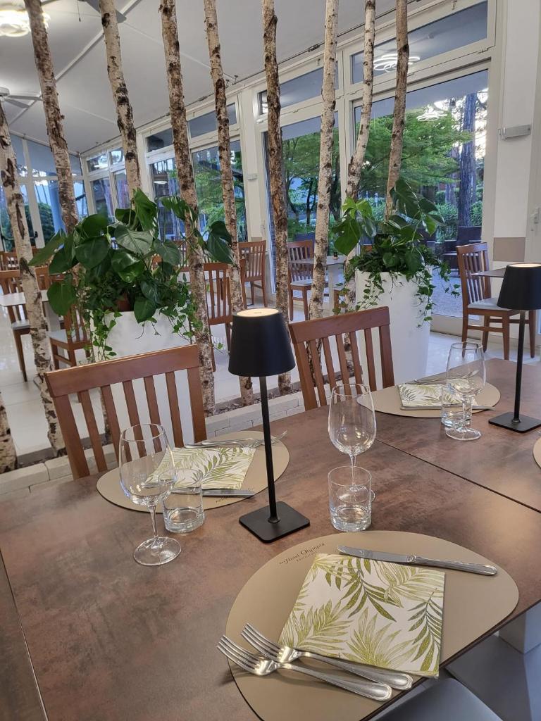 une salle à manger avec une table avec des assiettes et des verres dans l'établissement Hotel Olympia, à Lignano Sabbiadoro