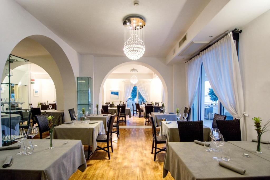un restaurant avec des tables, des chaises et un lustre dans l'établissement Terrazza Marconi Hotel&Spamarine, à Senigallia