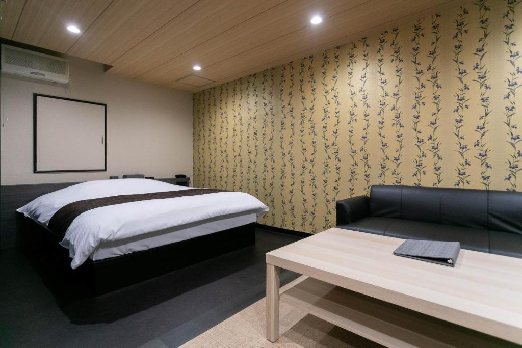 une chambre avec un lit et un canapé dans l'établissement Hotel TEMARI Matsumoto, à Matsumoto
