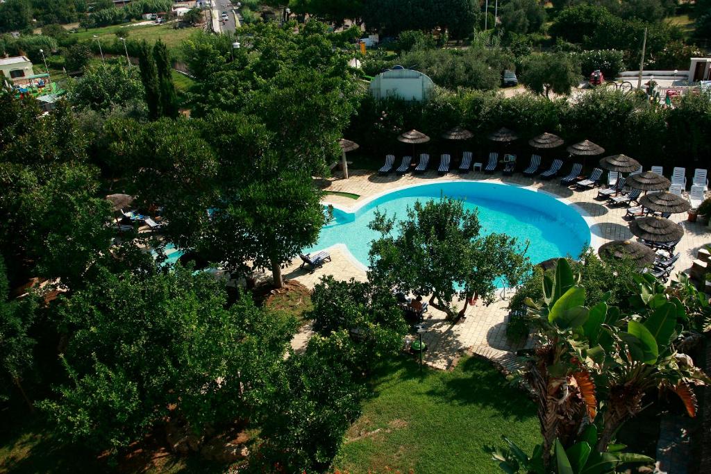 - une vue sur la piscine bordée de chaises et d'arbres dans l'établissement Park Hotel Valle Clavia, à Peschici