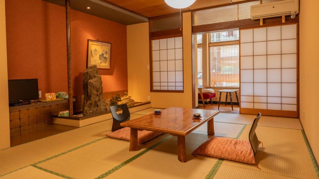 un salon avec une table et deux chaises dans l'établissement Andaikan, à Yamanouchi