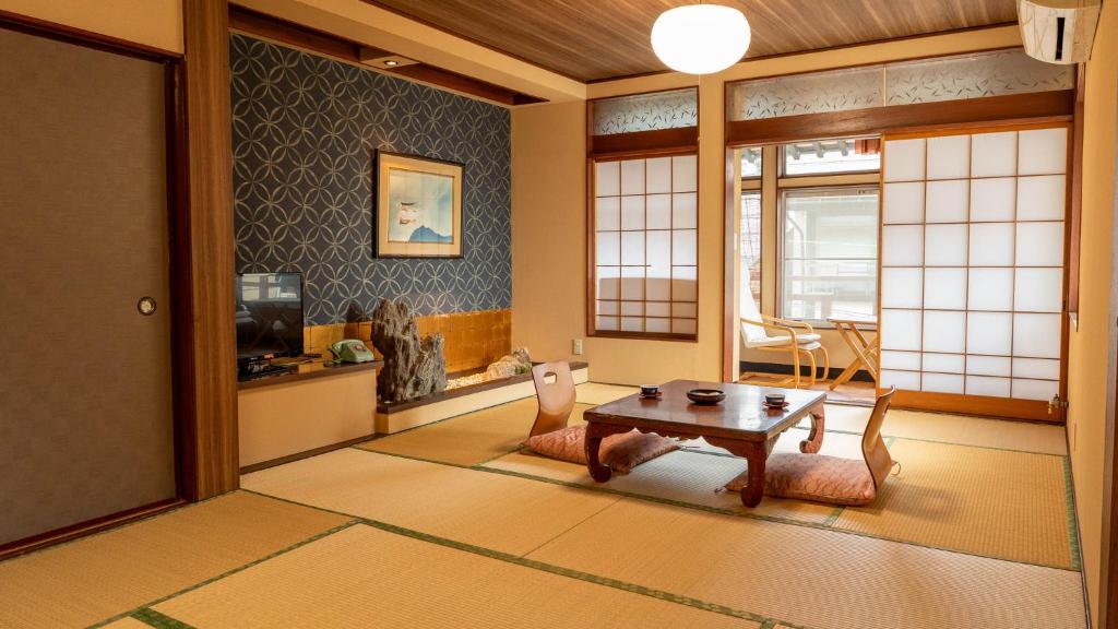 une pièce avec une table et des chaises dans une pièce dans l'établissement Andaikan, à Yamanouchi