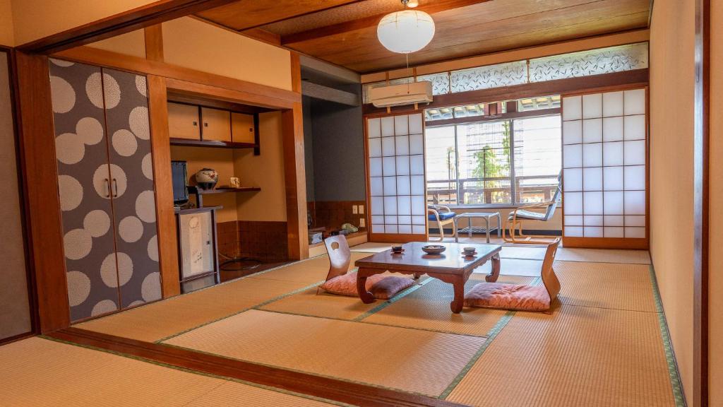 un salon avec une table et une salle à manger dans l'établissement Andaikan, à Yamanouchi