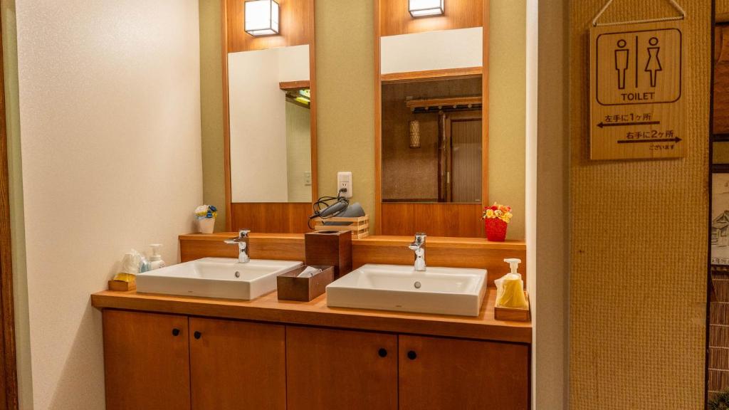 une salle de bain avec deux lavabos et un miroir dans l'établissement Andaikan, à Yamanouchi