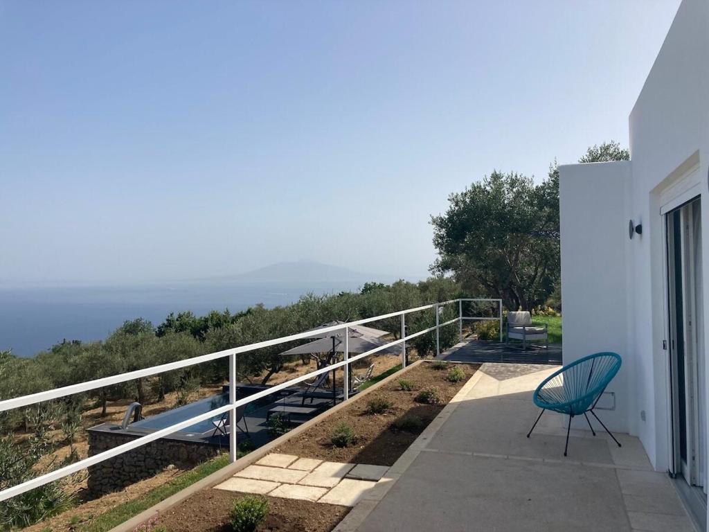 une chaise verte assise sur un balcon d'une maison dans l'établissement “CapriOleum” esclusive place, à Anacapri