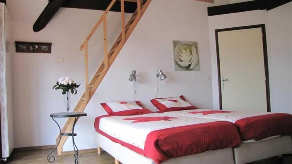 - une chambre avec un lit rouge et blanc et un escalier dans l'établissement Camping 3 étoiles - Piscine - ccagief, à Banes