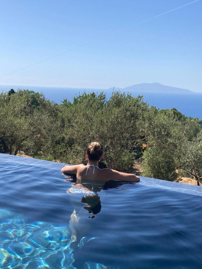un homme dans une piscine à débordement dans l'eau dans l'établissement “CapriOleum” esclusive place, à Anacapri