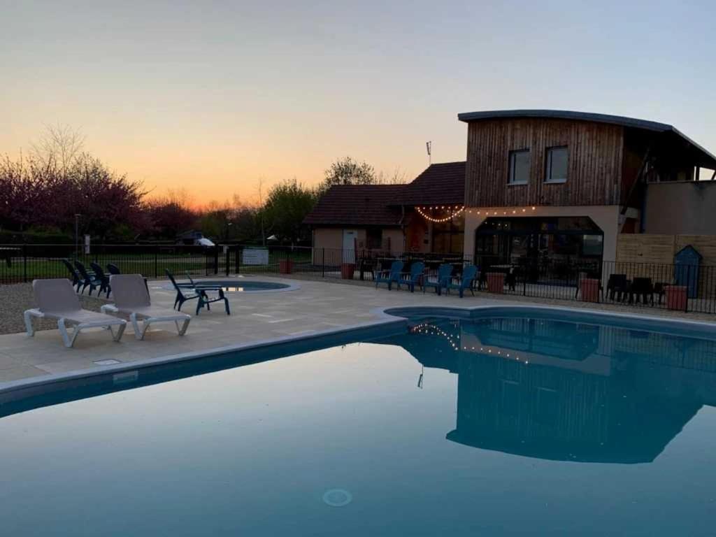 une piscine avec des chaises et une maison dans l'établissement Camping 3 étoiles - Piscine - ccaidda, à Cormatin