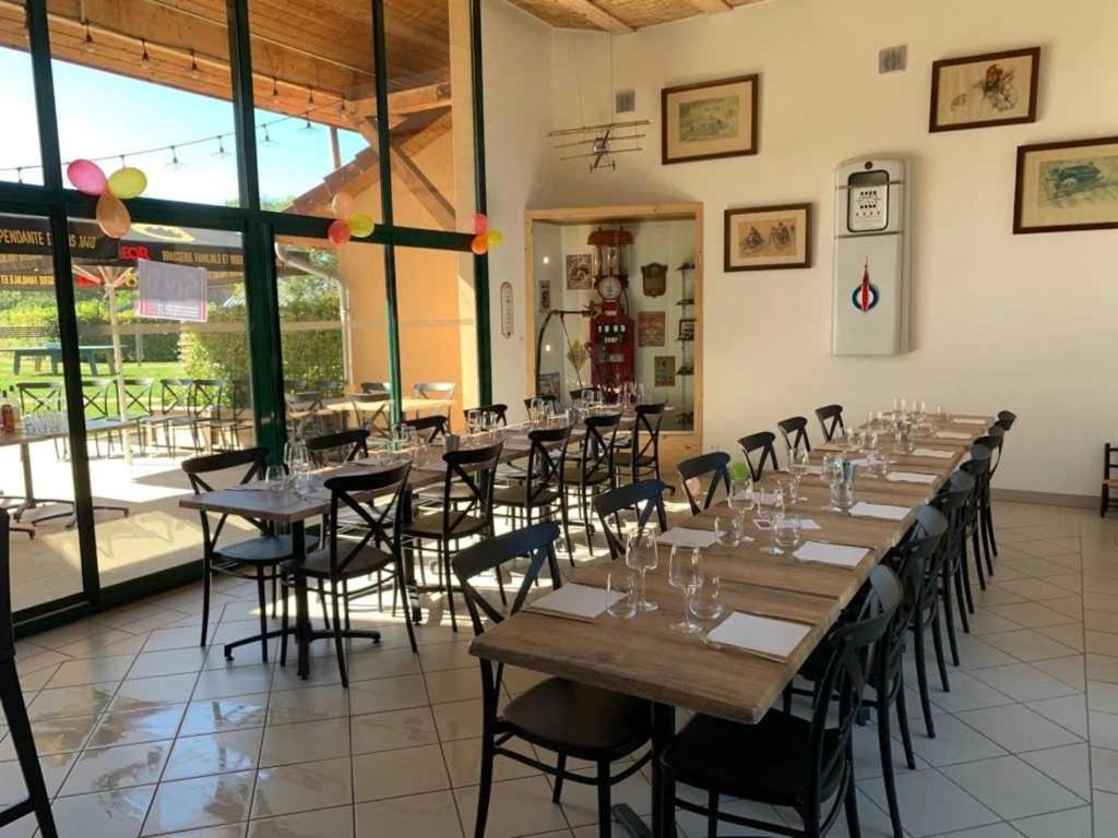 une grande chambre avec des tables et des chaises et des lunettes. dans l'établissement Camping 3 étoiles - Piscine - ccaidda, à Cormatin