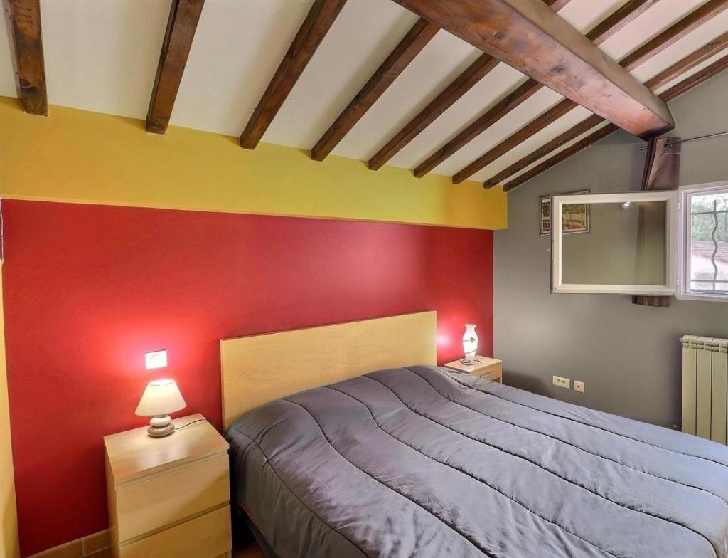 une chambre avec un lit et un mur rouge dans l'établissement EL ROCIO 1 GITES EQUESTRE, à Saintes-Maries-de-la-Mer 12 autres photos